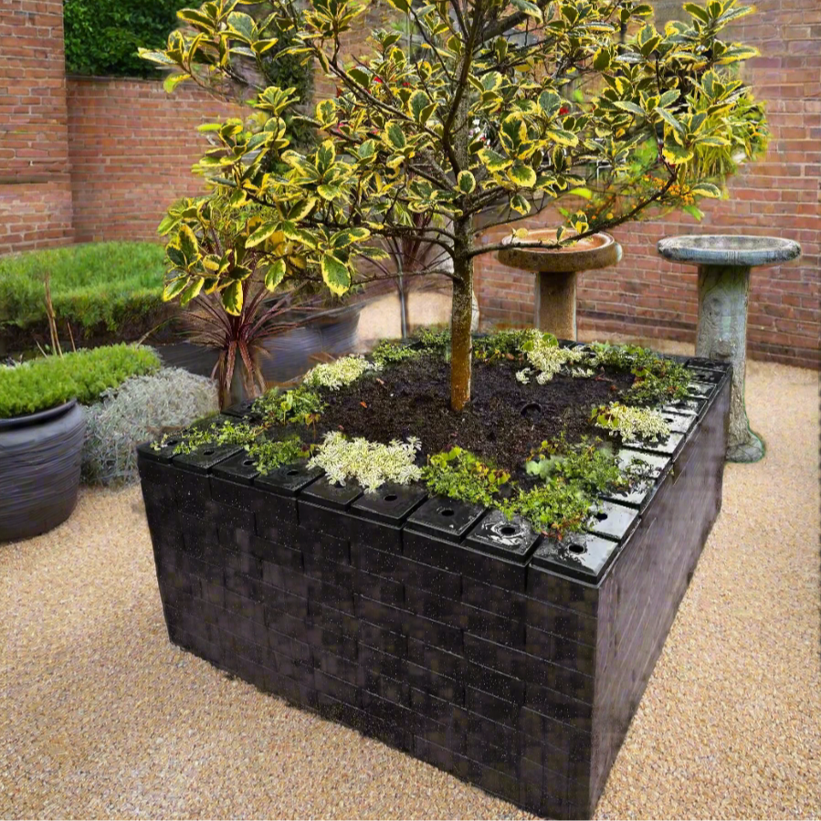 PolyBrick garden planter made from recycled plastic bricks, planted with variegated tree and flowers